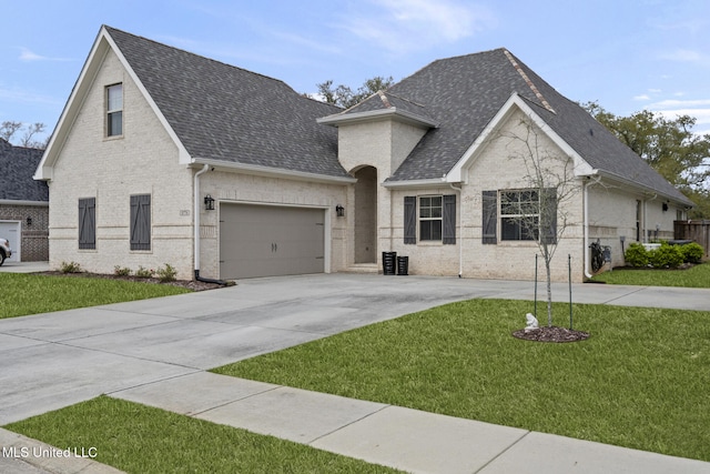 view of front of home with a garage, brick siding, concrete driveway, and a front lawn