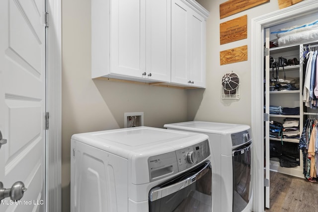 laundry area featuring cabinet space, independent washer and dryer, and wood finished floors