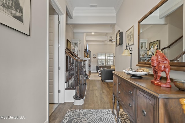 entryway with visible vents, beamed ceiling, dark wood finished floors, crown molding, and ceiling fan