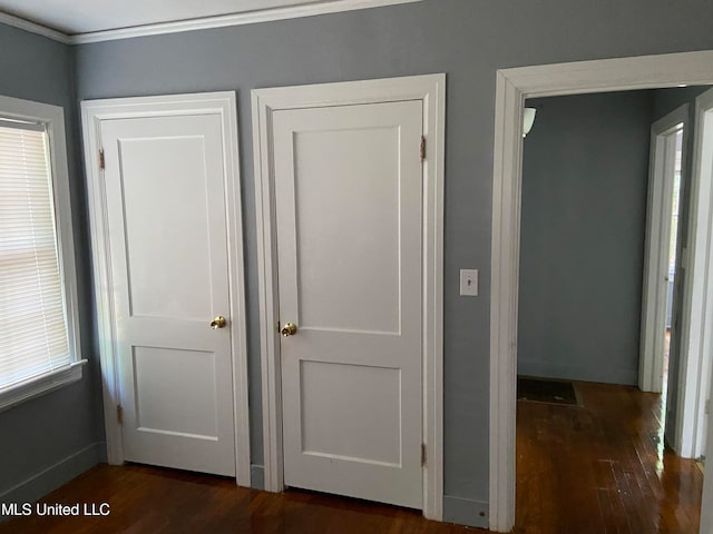 hall with dark wood-type flooring and crown molding