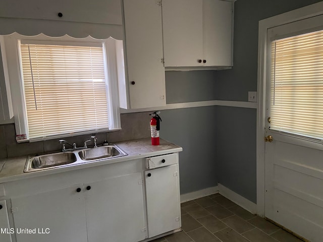 kitchen featuring a wealth of natural light, sink, and white cabinets