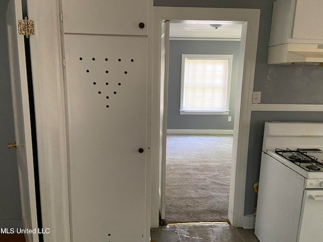 kitchen featuring carpet, extractor fan, white cabinetry, white gas stove, and ornamental molding