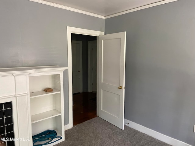 interior space featuring crown molding and dark colored carpet