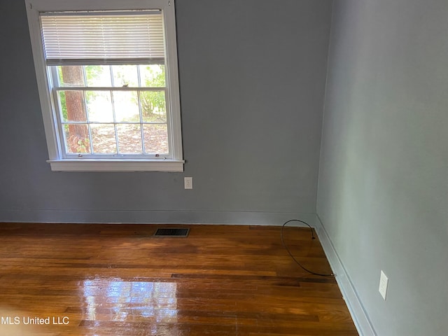 empty room with dark hardwood / wood-style flooring