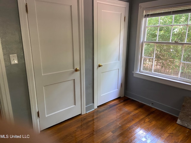 unfurnished bedroom with dark wood-type flooring