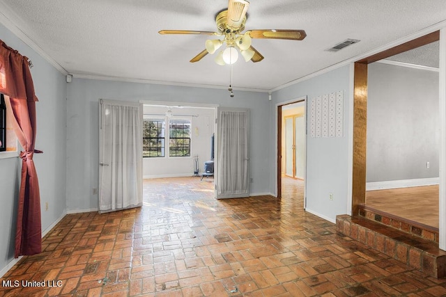 spare room with ceiling fan, ornamental molding, and a textured ceiling