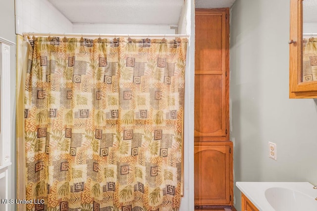 bathroom featuring a shower with curtain, vanity, and a textured ceiling