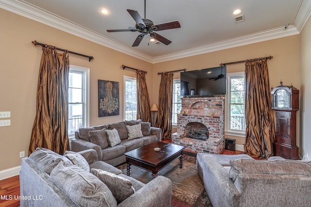 living room featuring dark wood-type flooring, ceiling fan, ornamental molding, and a brick fireplace