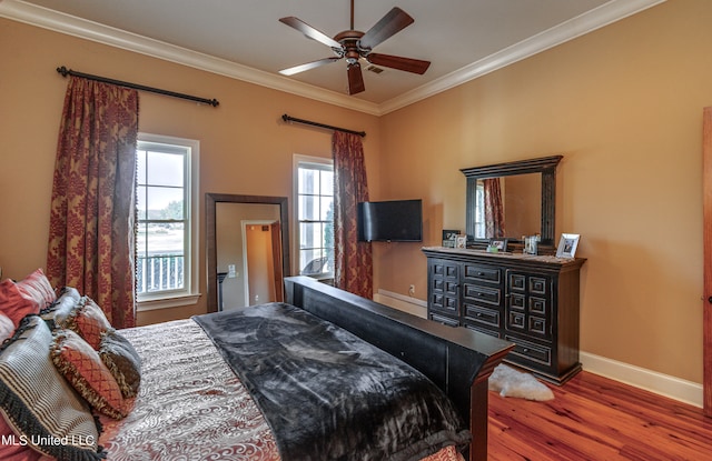 bedroom featuring crown molding, wood-type flooring, and ceiling fan