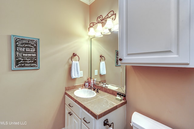 bathroom with vanity, ornamental molding, and toilet