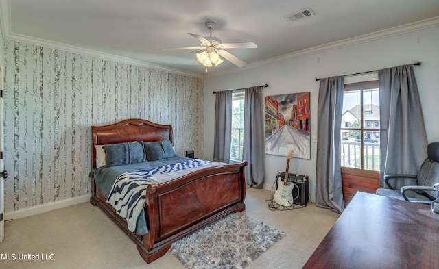 carpeted bedroom with ornamental molding and ceiling fan