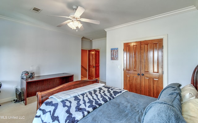 carpeted bedroom with crown molding, a closet, and ceiling fan