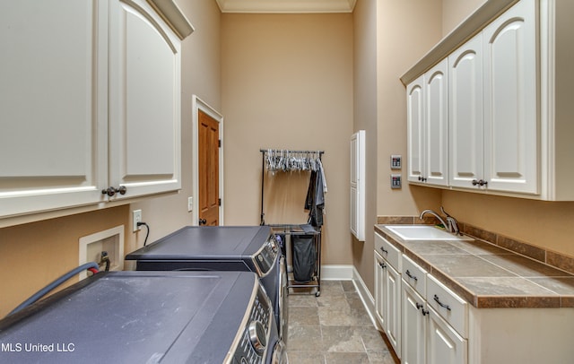 washroom featuring cabinets, sink, and washing machine and dryer