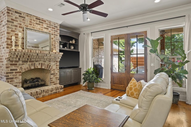 133 Sycamore Rdg, Madison, MS 39110 - living room featuring crown molding, wood finished floors, french doors, ceiling fan, and a brick fireplace