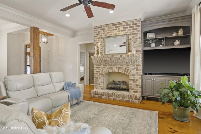 133 Sycamore Rdg, Madison, MS 39110 - living room featuring crown molding, a ceiling fan, wood finished floors, a fireplace, and recessed lighting