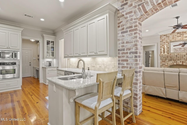 133 Sycamore Rdg, Madison, MS 39110 - kitchen featuring appliances with stainless steel finishes, a sink, ceiling fan, white cabinetry, and light wood-style floors