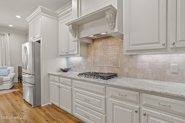 133 Sycamore Rdg, Madison, MS 39110 - kitchen featuring appliances with stainless steel finishes, custom range hood, white cabinetry, light wood-style floors, and crown molding
