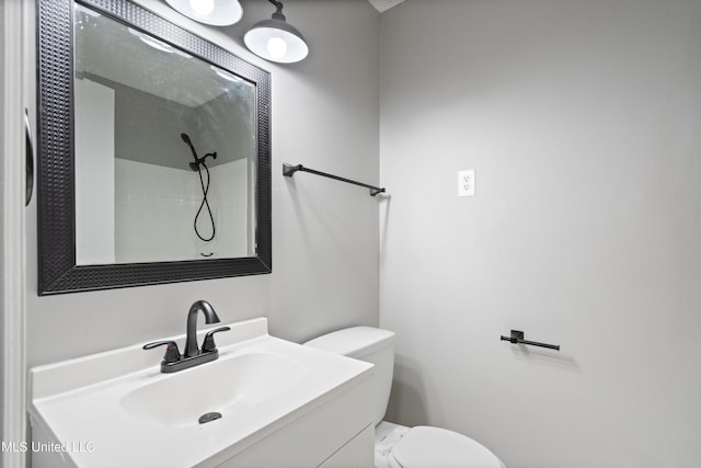 bathroom featuring a shower, toilet, and vanity