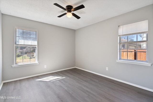 empty room with a textured ceiling, a ceiling fan, baseboards, and wood finished floors