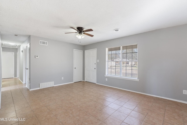 spare room featuring baseboards, visible vents, attic access, and ceiling fan