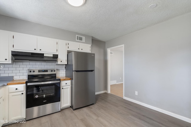 kitchen with tasteful backsplash, wooden counters, under cabinet range hood, appliances with stainless steel finishes, and white cabinets