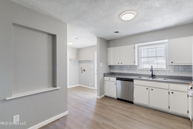 kitchen with a sink, tasteful backsplash, white cabinetry, light wood-style floors, and dishwasher