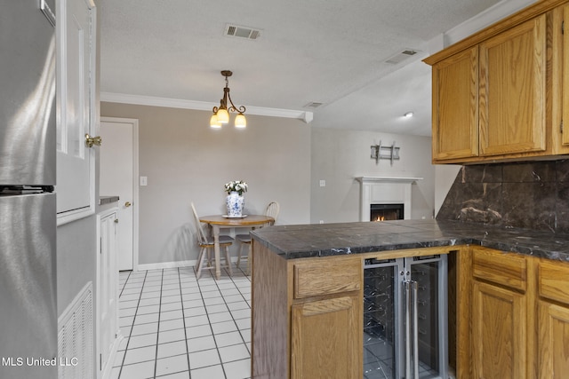 4504 E Magnolia Cv, Diberville, MS 39540 - kitchen with wine cooler, freestanding refrigerator, a peninsula, decorative backsplash, and light tile patterned floors