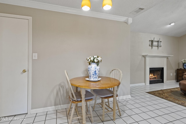 4504 E Magnolia Cv, Diberville, MS 39540 - dining space featuring a warm lit fireplace, a textured ceiling, light tile patterned floors, baseboards, and ornamental molding