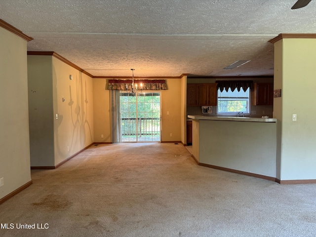 390 Green Rd, Yazoo City, MS 39194 - unfurnished living room featuring a wealth of natural light, light carpet, an inviting chandelier, and crown molding