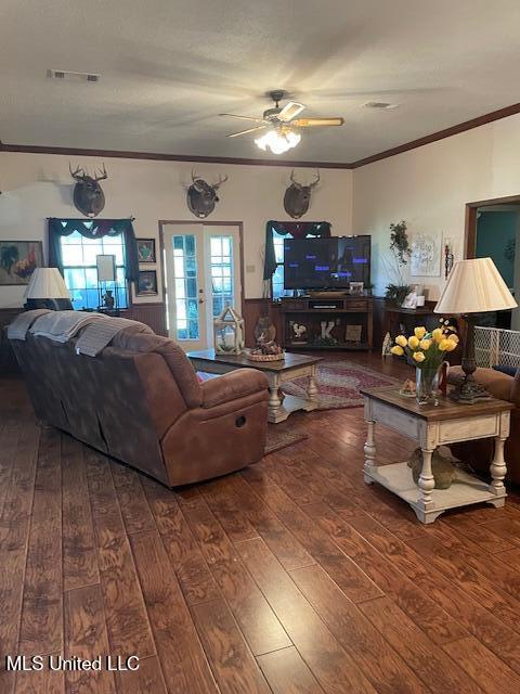 living area with visible vents, french doors, crown molding, and hardwood / wood-style flooring