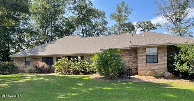 single story home with brick siding and a front yard