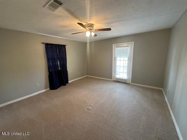 carpeted empty room with visible vents, baseboards, and a textured ceiling