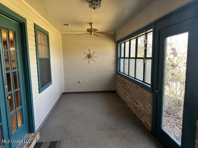 unfurnished sunroom with visible vents and ceiling fan