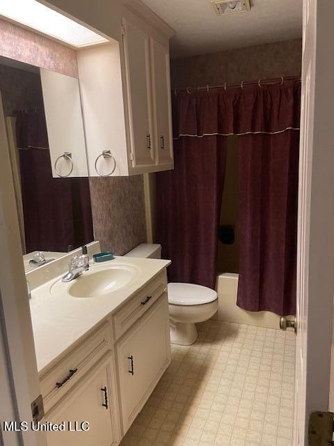 full bath with tile patterned floors, visible vents, toilet, shower / tub combo, and vanity