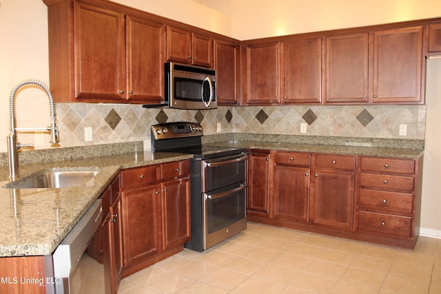 8855 Parkview Oaks Cir, Olive Branch, MS 38654 - kitchen with light stone countertops, appliances with stainless steel finishes, decorative backsplash, and a sink