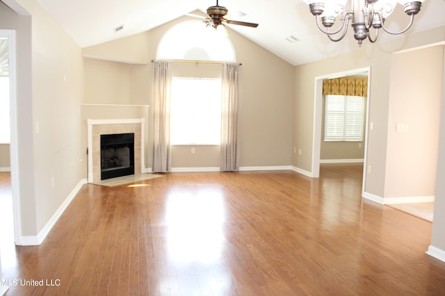 8855 Parkview Oaks Cir, Olive Branch, MS 38654 - unfurnished living room featuring a tile fireplace, baseboards, ceiling fan with notable chandelier, light wood finished floors, and lofted ceiling