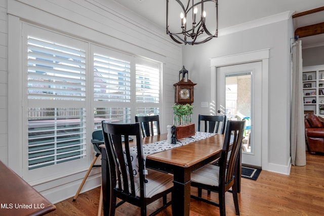 dining space featuring plenty of natural light, light wood-type flooring, and an inviting chandelier