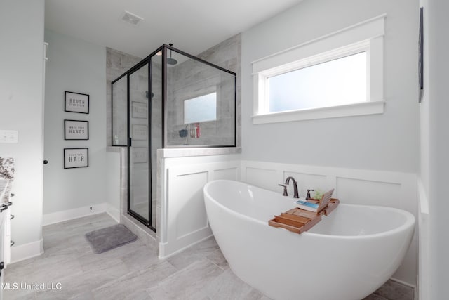 full bathroom featuring a wainscoted wall, visible vents, a soaking tub, a stall shower, and a decorative wall