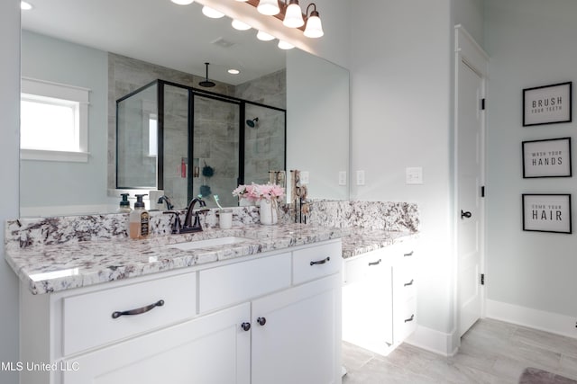 bathroom featuring visible vents, a shower stall, vanity, and baseboards