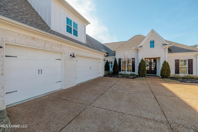 view of front facade featuring brick siding, board and batten siding, concrete driveway, and a shingled roof