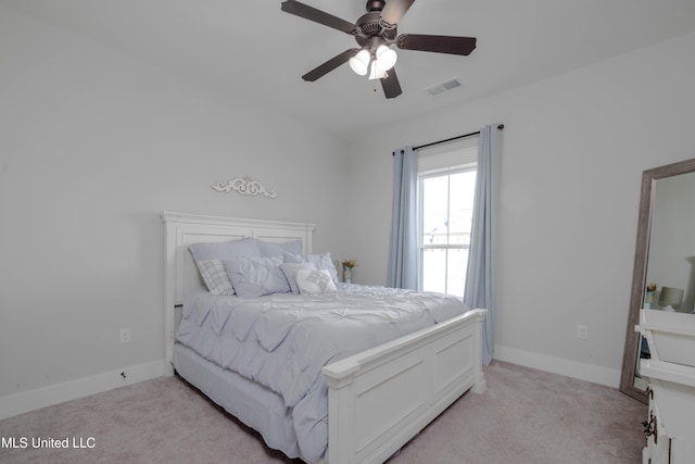 bedroom featuring a ceiling fan, light colored carpet, visible vents, and baseboards