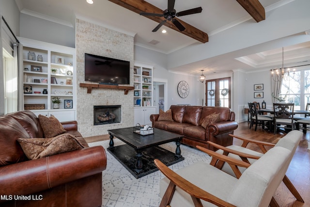 living room featuring beam ceiling, wood finished floors, a wealth of natural light, and ornamental molding