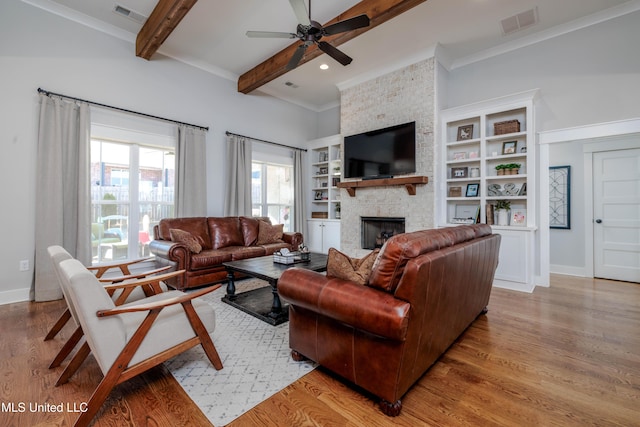 living room featuring visible vents, beamed ceiling, and wood finished floors