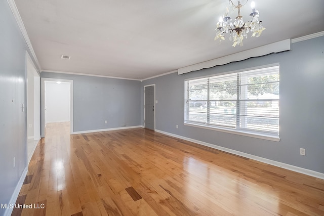 spare room with crown molding, light hardwood / wood-style floors, and a notable chandelier