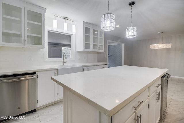 kitchen with white cabinets, dishwasher, a kitchen island, and sink