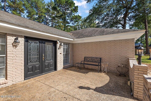 125 Lakeview Dr, Canton, MS 39046 - entrance to property with french doors, roof with shingles, a patio area, and brick siding