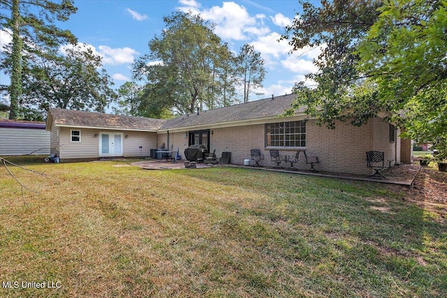 125 Lakeview Dr, Canton, MS 39046 - back of house featuring french doors, a patio area, a lawn, and brick siding