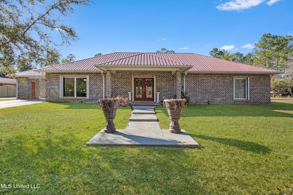 ranch-style house featuring french doors and a front lawn