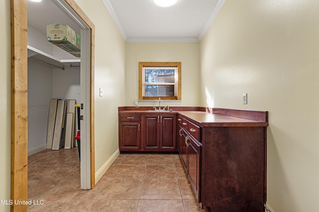 interior space featuring light tile patterned flooring, crown molding, and sink