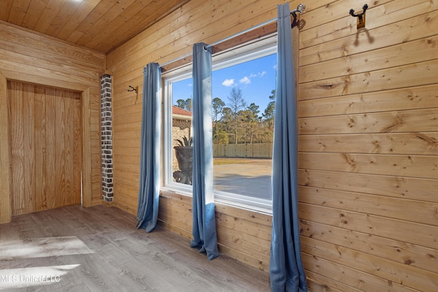 doorway featuring hardwood / wood-style flooring, wood walls, and wooden ceiling